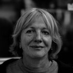 Expressive black and white portrait of a middle-aged woman with a gentle smile and a calm demeanor.